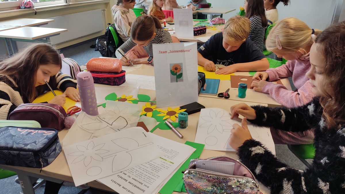 Schüler malen und zeichnen in einem Klassenzimmer gemeinsam.